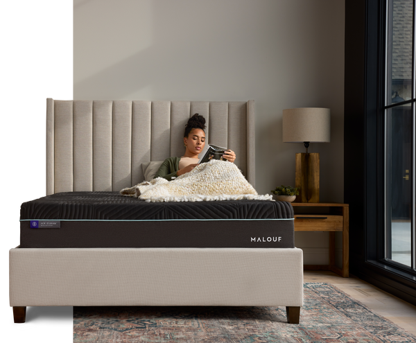 Woman laying on mattress reading a book